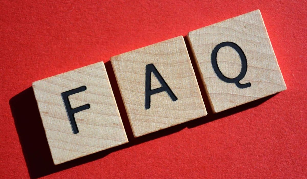 FAQ acronym for Frequently Asked Questions in 3D wooden alphabet letters on a bright red background